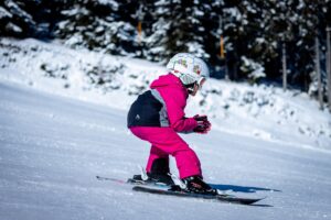Une petite fille dévale les pistes avec ses skis