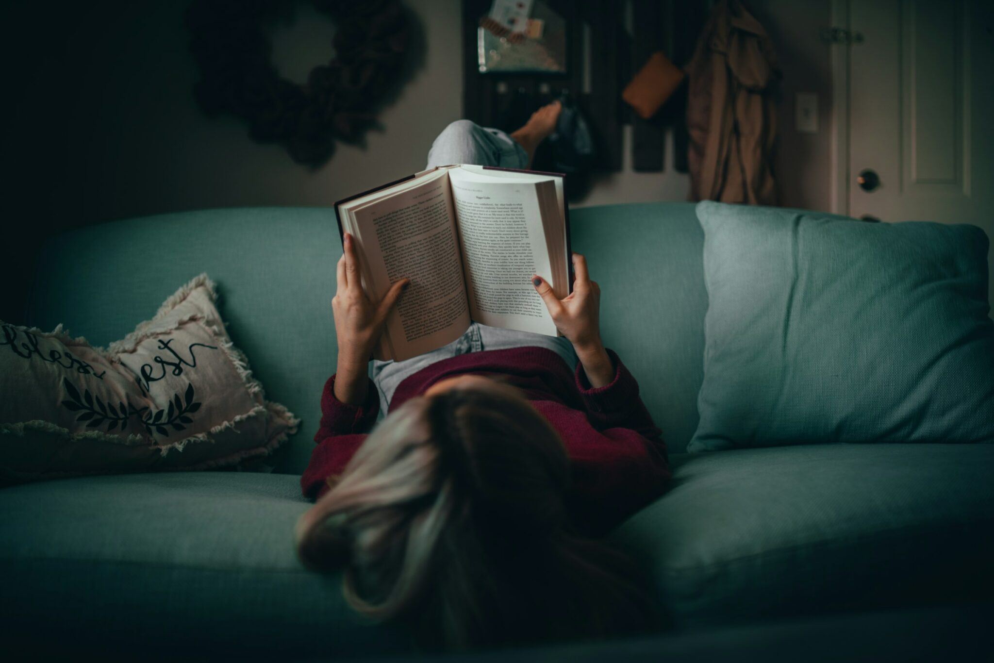Personne qui lit un livre sur un canapé