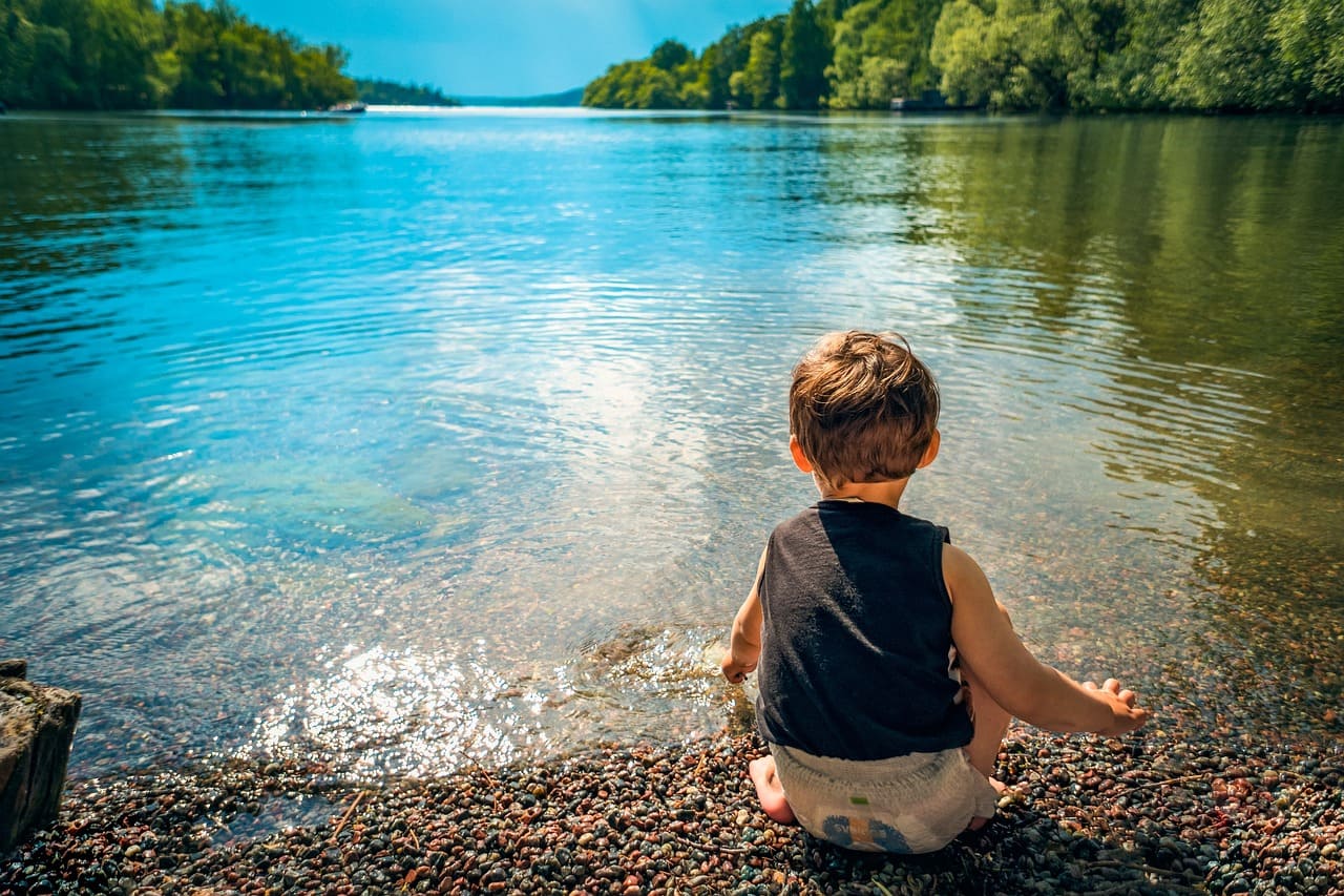Jeune enfant au bord d'un lac