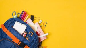Fournitures scolaires qui sortent d'un sac à dos