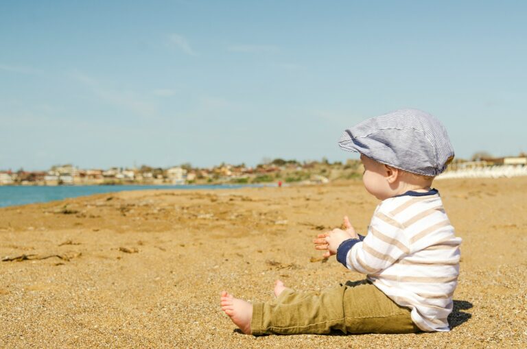 Un bébé assis sur le sable à la plage